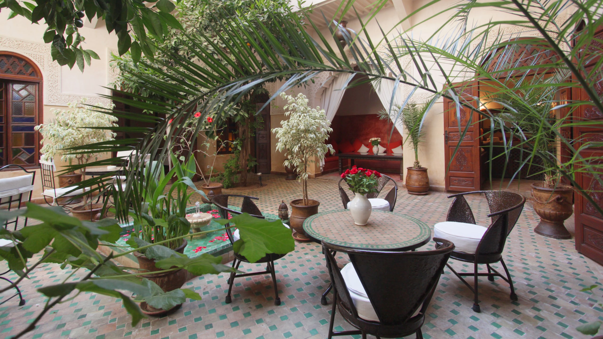 Le patio planté et le salon rouge du Riad Massiba en pleine journée