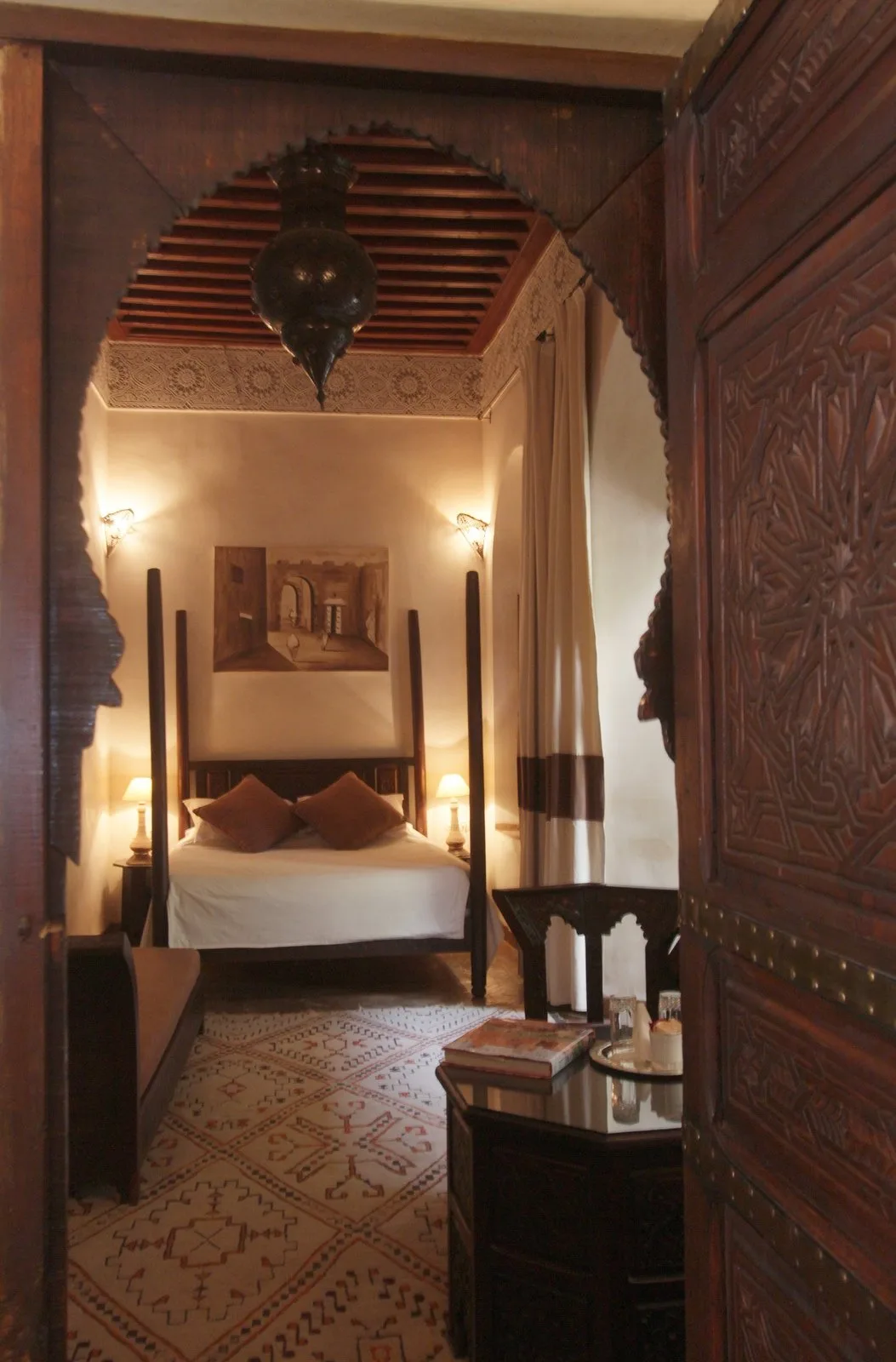 La chambre Cannelle encadrée par sa porte en bois sculpté
